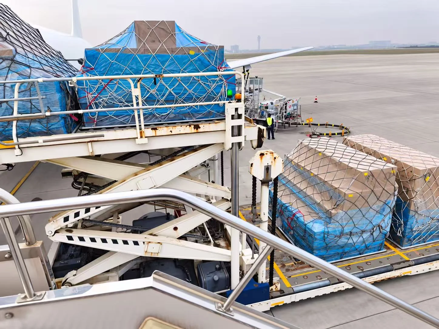 Covered air cargo pallets secured with nets on the loading platform.
