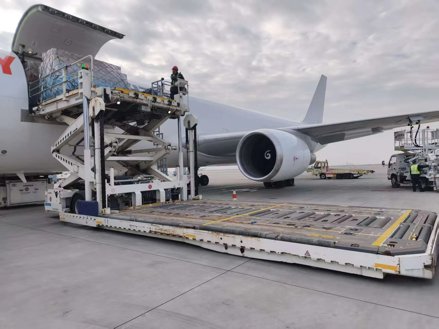 Palletized freight lifted to the aircraft cargo door.